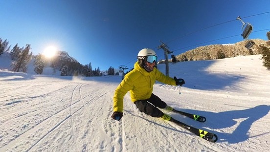 Olly carving a turn on a groomed piste in the morning sun